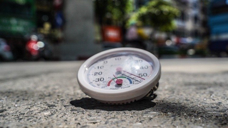 Lúc 10h, nhiệt độ ngoài trời tại Hà Nội khoảng 36 độ C, nhưng nhiệt độ đo thực tế trên mặt đường vượt mức 50 độ C, cường độ ánh sáng rất mạnh. Ảnh (tienphong)