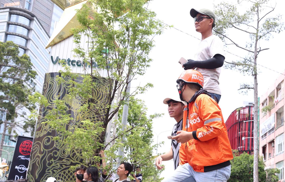 Một bạn trẻ làm công việc giao hàng công nghệ, cũng tranh thu chờ ngắm siêu xe.