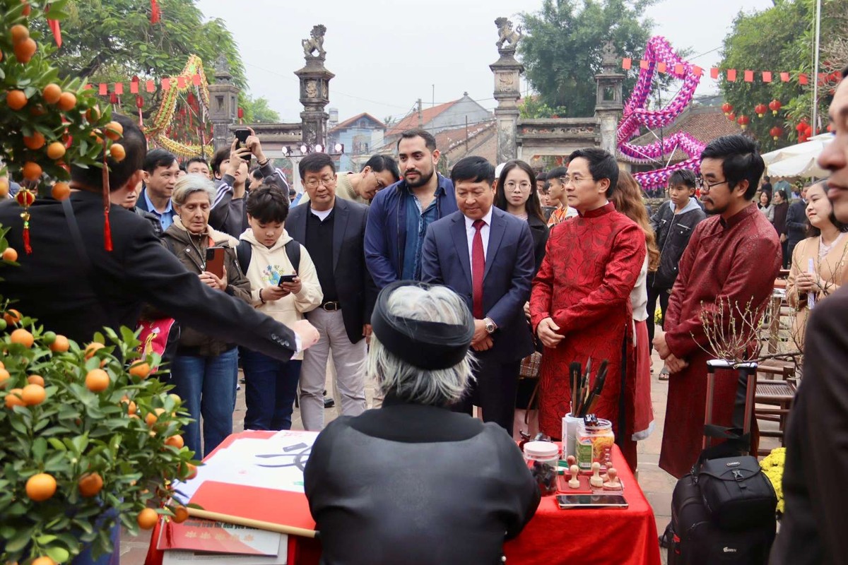 Bí thư Thị ủy Sơn Tây Trần Anh Tuấn cùng các đại sứ quán, du khách xin chữ ông đồ.