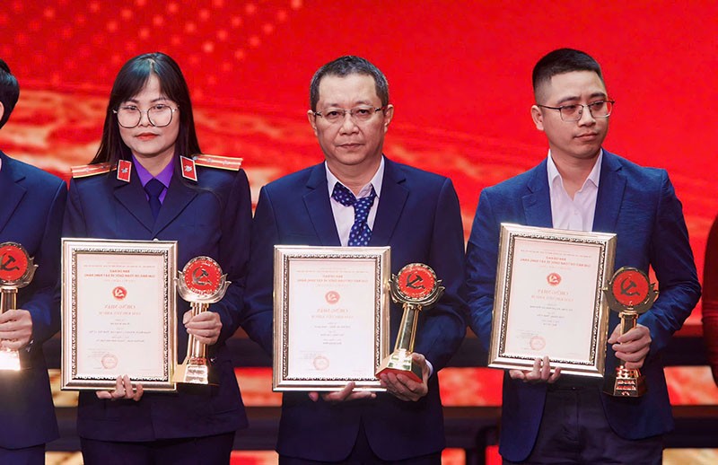 Nhà báo Ngô Song Sơn (đứng giữa) nhận cúp và bằng khen của Ban Tổ chức. Ảnh: Chí Cường