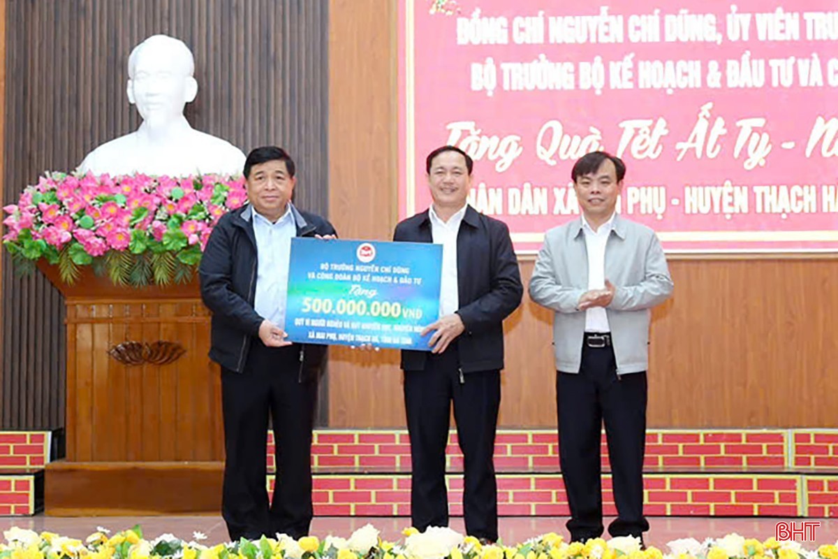 Bộ trưởng Nguyễn Chí Dũng trao biểu trưng tặng 500 triệu đồng cho xã Mai Phụ. (Ảnh: BHT)