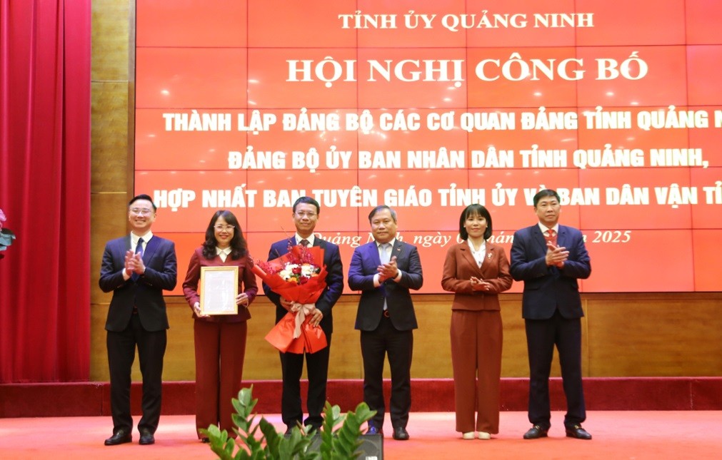 Bí thư Tỉnh ủy Quảng Ninh trao quyết định hợp nhất Ban Tuyên giáo Tỉnh ủy và Ban Dân vận Tỉnh ủy thành Ban Tuyên giáo và Dân vận Tỉnh ủy. Ảnh: Thu Chung