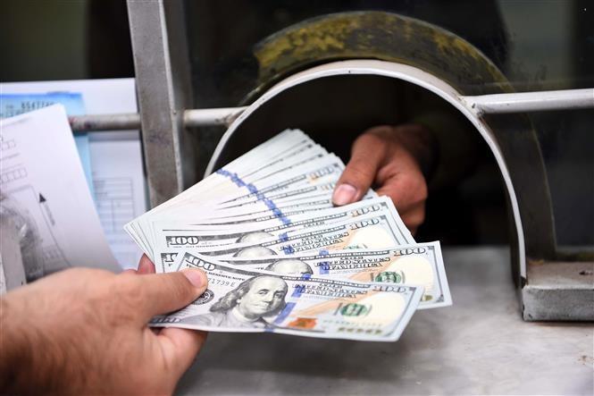Giao dịch đồng USD tại Rawalpindi, Pakistan. Ảnh: THX/TTXVN Giao dịch đồng USD tại Rawalpindi, Pakistan. Ảnh: THX/TTXVN