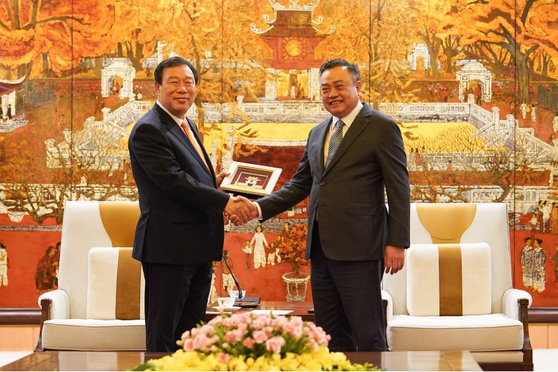 Chủ tịch UBND Thành phố Trần Sỹ Thanh trao quà lưu niệm của Hà Nội cho đoàn công tác thành phố Sejong. Ảnh: Hoàng Linh