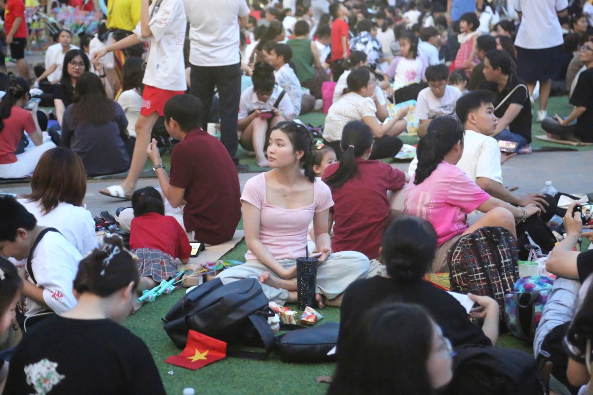 Bạn trẻ Minh Ngọc (áo hồng), ngụ tại quận Bình Tân (TP.HCM), cho biết có mặt từ 16 giờ tại Bến Bạch Đằng để chụp hình cùng đại bác và ngồi chờ đến giờ xem bắn pháo hoa