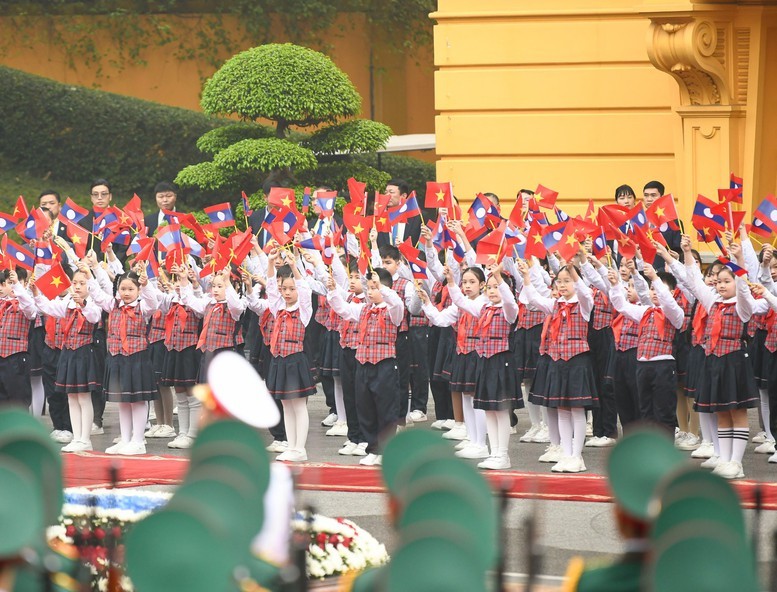 Các em thiếu niên, học sinh hân hoan chào đón Tổng Bí thư, Chủ tịch nước Lào Thongloun Sisoulith cùng Phu nhân và Đoàn đại biểu Cấp cao Đảng, Nhà nước Lào - Ảnh: VGP/Nhật Bắc