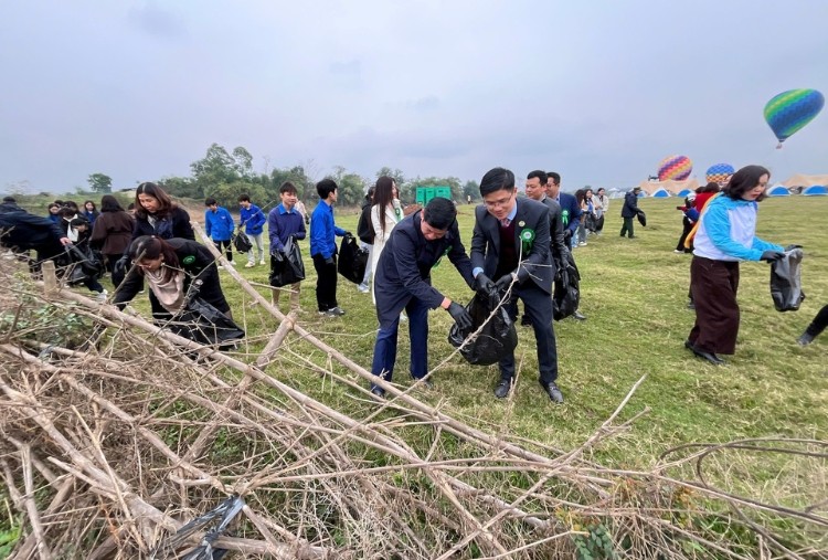 Các đại biểu và người dân cùng du khách tham gia nhặt rác để phát động du lịch xanh, thân thiện môi trường tại Đa Phúc.
