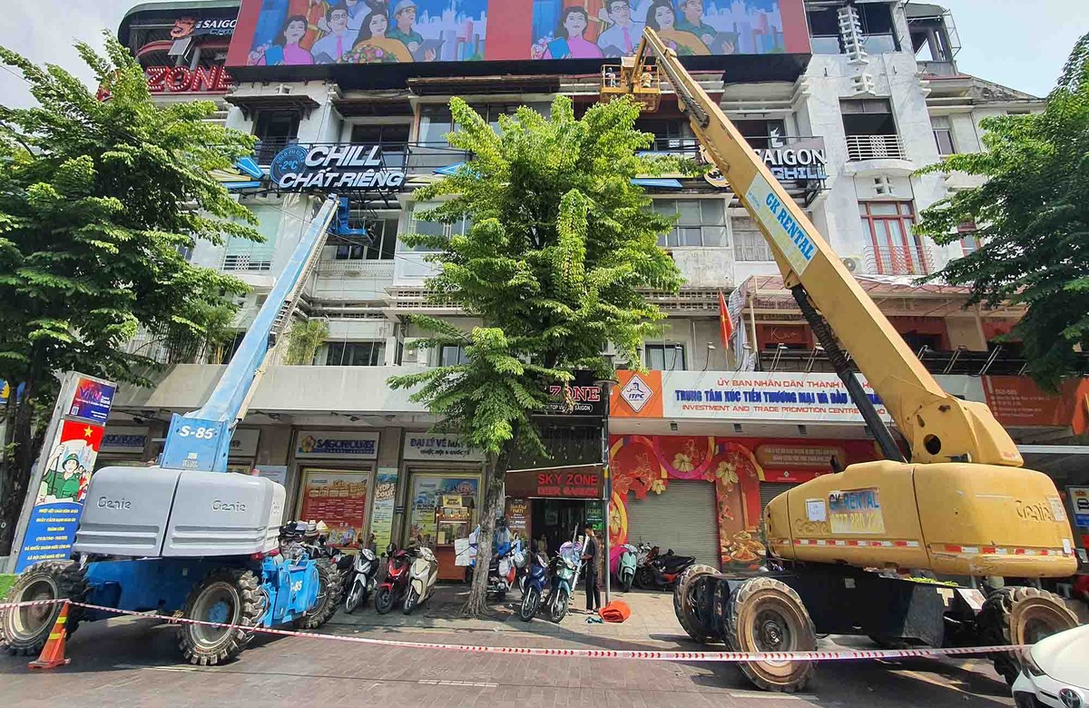 Các thiết bị chuyên dụng đang sơn mầu mới trên đường Nguyễn Huệ.