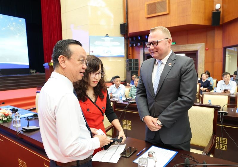 Phó chủ tịch UBND TP.HCM Bùi Minh Thạnh (bên trái) trao đổi với doanh nghiệp bên lề hội nghị - Ảnh: L.A