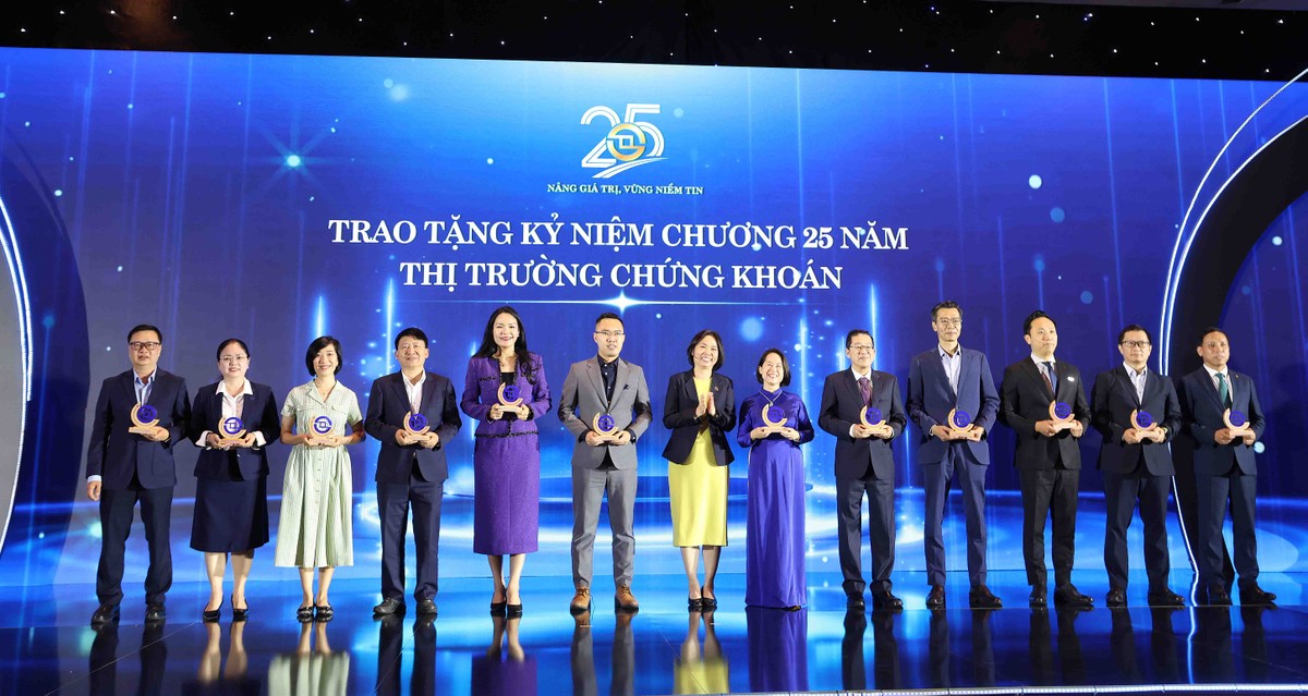 Bà Trần Anh Đào (đứng thứ 7 từ trái sang) đại diện HOSE trao kỷ niệm chương (Ảnh: Lê Toàn)