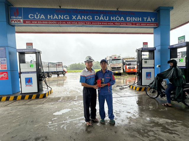 Ông Ngô Văn Nhiệm - Giám đốc PVOIL Phú Yên trao thưởng cho anh Hồ Quốc Hưng - nhân viên CHXD Hòa Định Tây (người mặc đồng phục xanh) đã có hành động dũng cảm cứu người