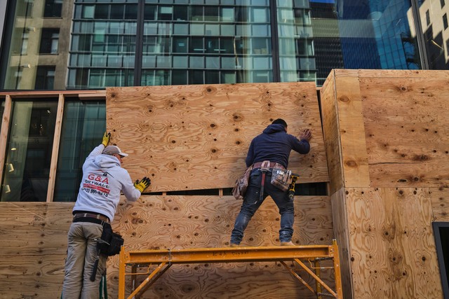 Các công nhân dựng rào chắn các ô cửa tại Manhattan