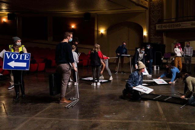 Các nhân viên dọn dẹp điểm bầu cử sau khi bỏ phiếu xong