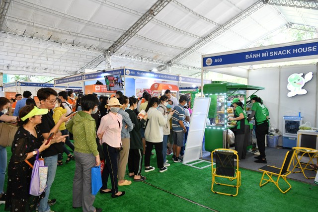 Người dân và du khách xếp hàng thưởng thức món ngon tại một gian hàng bánh mì.