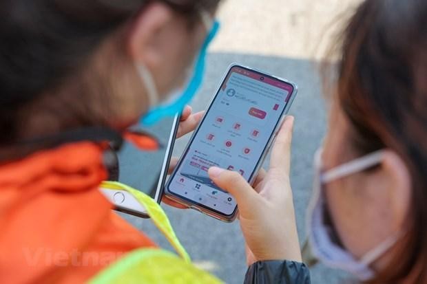 Nhân viên của nhà cung cấp thu phí không dừng hướng dẫn tạo tài khoản, nạp tiền cho chủ phương tiện để sử dụng dịch vụ. (Ảnh: Minh Sơn/Vietnam+).