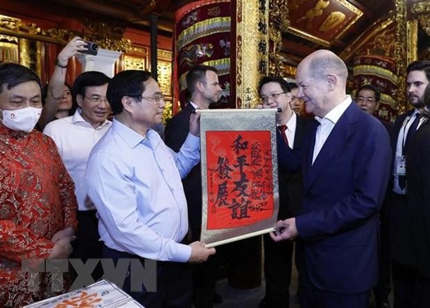 Thủ tướng Phạm Minh Chính tặng Thủ tướng Đức Olaf Scholz bức thư pháp với nội dung &quot;Hòa bình - Hữu nghị cùng phát triển&quot; tại đền Ngọc Sơn.(Ảnh: An Đăng/TTXVN).