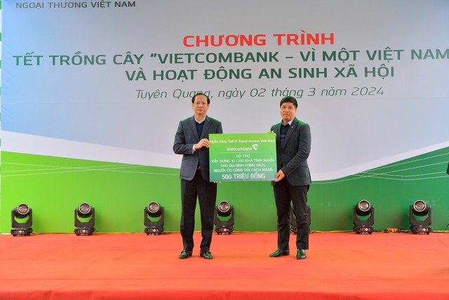 Ông Hồng Quang - Ủy viên BTV Đảng ủy, Thành viên HĐQT, Chủ tịch Công đoàn Vietcombank (bên phải) trao biển tượng trưng kinh phí xây dựng 10 căn nhà tình nghĩa cho đại diện lãnh đạo địa phương, ông Giang Tuấn Anh - Chủ tịch UBND huyện Sơn Dương