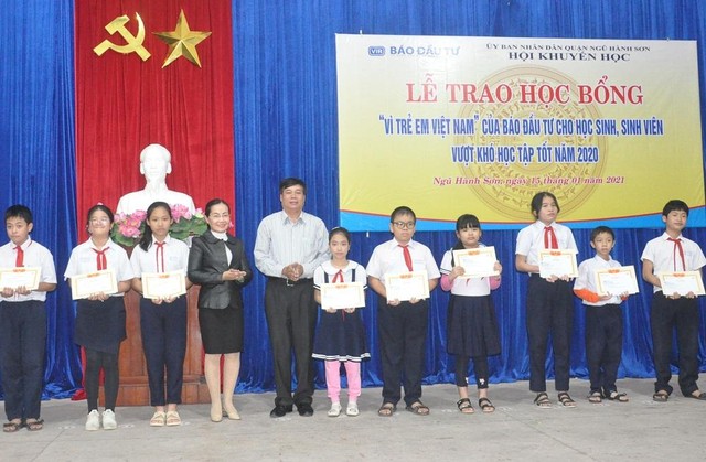 Ông Mai Niên và bà Nguyễn Thị Phượng trao học bổng cho các em học sinh.