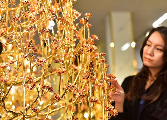 Đặc biệt, có cây hoa đào khá độc đáo do 21 người thợ, nghệ nhân thực hiện trong 6 tháng.Cây hoa đào được mạ 12 lượng vàng, trong đó chất liệu hoa pha 30% đồng đỏ và 70% vàng để tạo ra màu phù hợp với màu hồng của cây hoa đào. Hoa thiết kế theo truyền thống hoa đào 5 cánh kép 2 tầng, biểu trưng cho ngũ phúc kép của người Việt, mang đến hạnh phúc, bình an được nhân đôi. Sau khi mạ vàng, cây đào được mạ lên lớp nano để bảo vệ lớp vàng, chống bào mòn theo thời gian. Cây có giá trị 1,3 tỷ đồng. Đặc biệt, có cây hoa đào khá độc đáo do 21 người thợ, nghệ nhân thực hiện trong 6 tháng.Cây hoa đào được mạ 12 lượng vàng, trong đó chất liệu hoa pha 30% đồng đỏ và 70% vàng để tạo ra màu phù hợp với màu hồng của cây hoa đào. Hoa thiết kế theo truyền thống hoa đào 5 cánh kép 2 tầng, biểu trưng cho ngũ phúc kép của người Việt, mang đến hạnh phúc, bình an được nhân đôi. Sau khi mạ vàng, cây đào được mạ lên lớp nano để bảo vệ lớp vàng, chống bào mòn theo thời gian. Cây có giá trị 1,3 tỷ đồng.