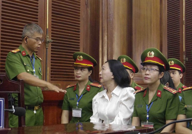 Bị cáo Lan trao đổi với cán bộ áp giải trước phiên tòa. Bị cáo Lan trao đổi với cán bộ áp giải trước phiên tòa.