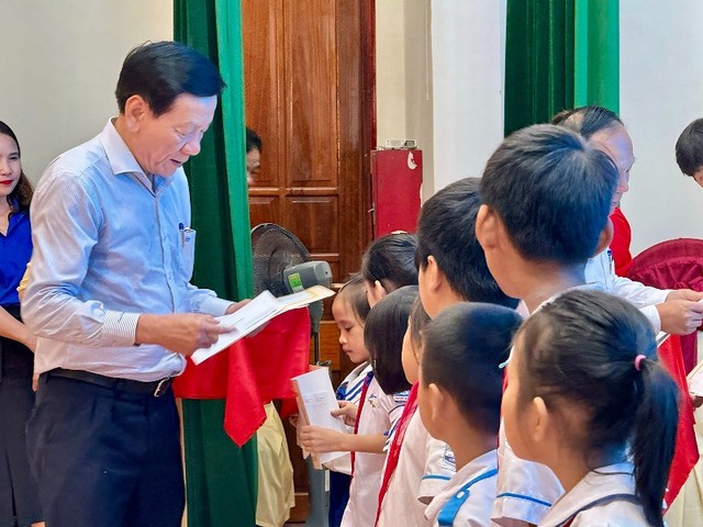 Ông Nguyễn Anh Tuấn, nguyên Tổng Biên tập Báo Đầu tư trao giấy chứng nhận và học bổng cho các em học sinh.