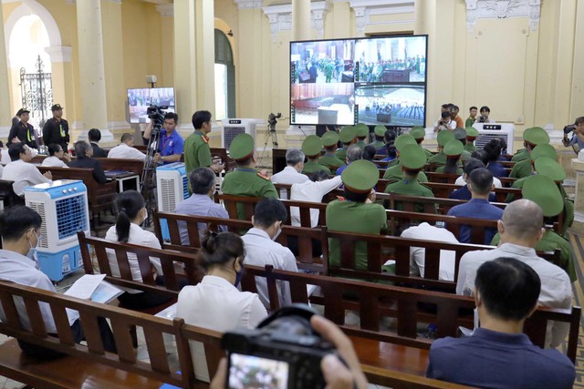 Các bị cáo theo dõi phiên toà thông qua màn hình bên ngoài phòng xét xử. Các bị cáo theo dõi phiên toà thông qua màn hình bên ngoài phòng xét xử.