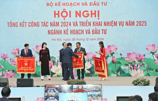 Ông Lê Trọng Minh, Tổng Biên tập Báo Đầu tư nhận Cờ Thi đua của Chính phủ từ Thủ tướng Chính phủ Phạm Minh Chính. Ảnh: Đức Thanh