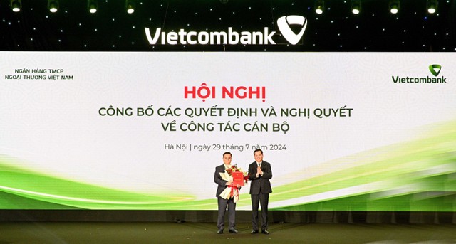 Đ/c Nguyễn Long Hải - Ủy viên dự khuyết BCH Trung ương Đảng, Bí thư Đảng ủy Khối DNTW (bên phải) trao Quyết định và tặng hoa chúc mừng đ/c Nguyễn Thanh Tùng, tân Bí thư Đảng ủy, Chủ tịch HĐQT Vietcombank