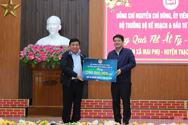 Bộ trưởng Nguyễn Chí Dũng trao biểu trưng tặng 200 triệu đồng cho Quỹ Vì người nghèo tỉnh Hà Tĩnh. (Ảnh: BHT)