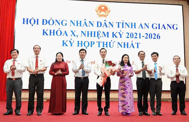 Bí thư Tỉnh ủy An Giang Nguyễn Tiến Hải (thứ 4 từ trái qua) tặng hoa cho các thành viên thường trực HĐND tỉnh.