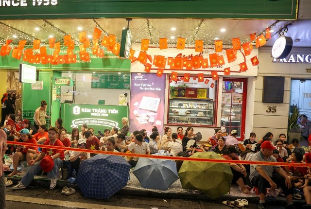 Khu vực có mái hiên trước cửa Công ty Kem Tràng Tiền cũng kín đặc từ 19h. Khu vực có mái hiên trước cửa Công ty Kem Tràng Tiền cũng kín đặc từ 19h.