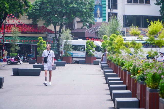 Những chậu cây và ghế đá được bố trí thành “hàng rào di động” ngăn cách lối đi bộ và làn xe trên phố Đinh Tiên Hoàng. Vào cuối tuần, hàng rào này có thể được dịch chuyển để mở rộng không gian đi bộ. Những chậu cây và ghế đá được bố trí thành “hàng rào di động” ngăn cách lối đi bộ và làn xe trên phố Đinh Tiên Hoàng. Vào cuối tuần, hàng rào này có thể được dịch chuyển để mở rộng không gian đi bộ.
