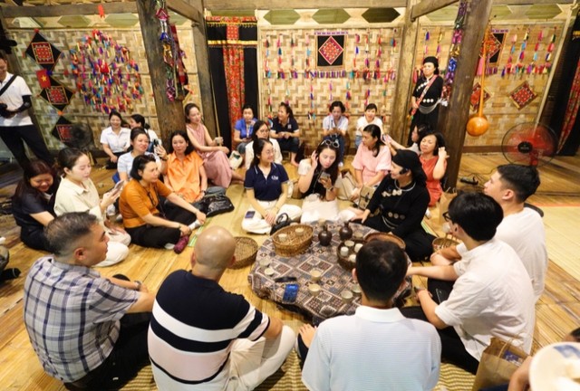 Các đại biểu thưởng thức rượu men lá và bánh chè lam tại nhà Rượu.