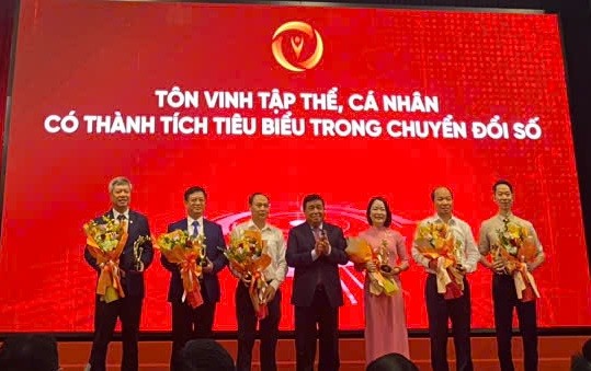 Phó chủ tịch TP.Đà Nẵng, ông Hồ Quang Bửu (bìa trái) thay mặt thành phố nhận hoa và tặng thưởng từ Phó thủ tướng Chính phủ Nguyễn Chí Dũng.