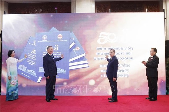 Tổng Bí thư Tô Lâm và Chủ tịch Quốc hội Lào Saysomphone Phomvihane cùng các đại biểu bấm nút khai trương sách điện tử. Ảnh: Thống Nhất/TTXVN.