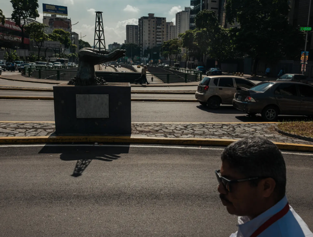 Một bức tượng hình bàn tay đang nâng giàn khoan dầu ở Caracas. Ảnh: NYT