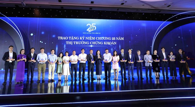 Phó Tổng Biên tập Lê Trọng Minh (đứng thứ 10 từ trái sang) đại diện cho Báo Tài chính - Đầu tư nhận kỷ niệm chương vì sự đồng hành cùng HOSE trong nhiều mùa tổ chức Cuộc Bình chọn Doanh nghiệp Niêm yết (Ảnh: Lê Toàn)