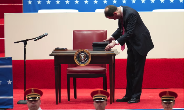 Chiếc bàn và ghế nhỏ với một chồng giấy tờ dường như là các sắc lệnh mà ông Trump sẽ thực hiện ký công khai.