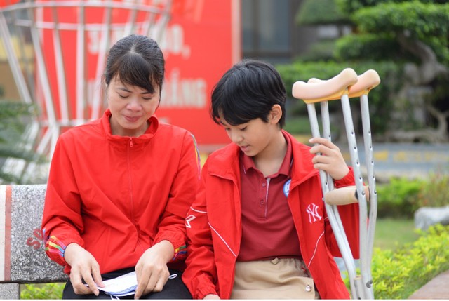 Bé T.K.L được mẹ đưa tới nhận học bổng.