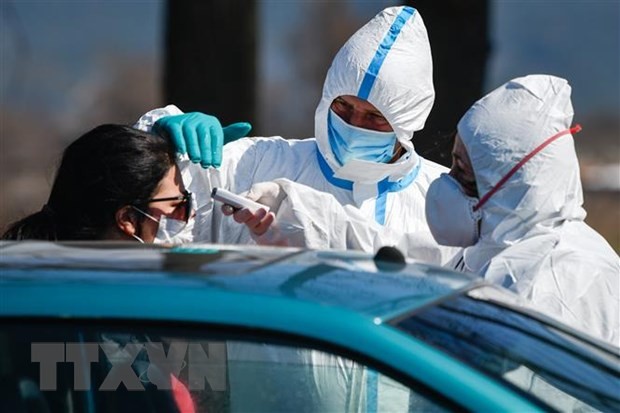 Nhân viên y tế kiểm tra thân nhiệt người dân tại một trạm kiểm soát ở Bansko, Bulgaria. (Ảnh: AFP/TTXVN).