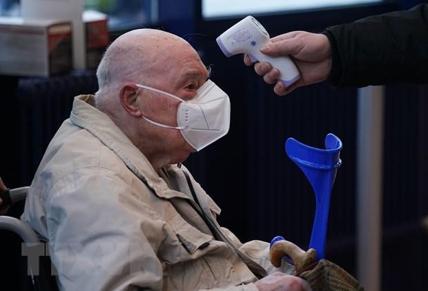 Kiểm tra thân nhiệt tại một trung tâm tiêm chủng ngừa COVID-19 ở Berlin, Đức. (Ảnh: AFP/TTXVN).