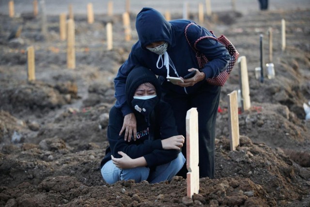 Một phụ nữ Indonesia khóc nấc bên nấm mộ sơ sài của người thân qua đời vì Covid-19 ngày 28/6. Ảnh: Reuters.
