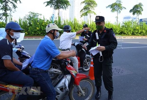 Lực lượng chức năng nhắc nhở người dân thực hiện nghiêm công tác phòng, chống dịch. (Ảnh: TTXVN).