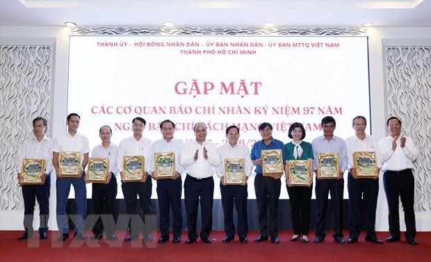 Chủ tịch nước Nguyễn Xuân Phúc tặng quà lưu niệm cho các Tổng Biên tập, Trưởng các cơ quan báo chí, nhà báo tiêu biểu trên địa bàn Thành phố Hồ Chí Minh. (Ảnh: Thống Nhất/TTXVN).