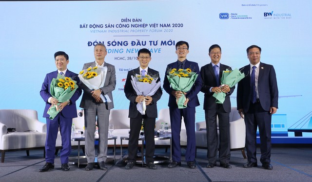 Ông Lê Trọng Minh (ngoài cùng bên phải) tặng hoa cho điều phối viên và các diễn giả tham gia phiên thảo luận thứ nhất - Ảnh: Lê Toàn.