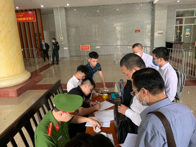 Nhiều người làm thủ tục tham dự phiên tòa.