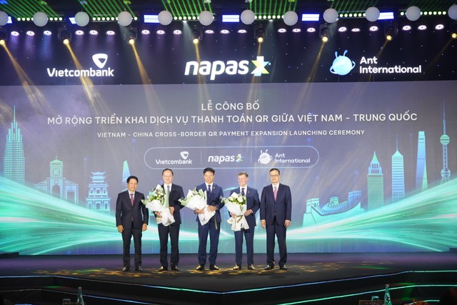 Các Phó Thống đốc Ngân hàng Nhà nước Việt Nam gồm ông Phạm Tiến Dũng và ông Phạm Quang Dũng tặng hoa chúc mừng lãnh đạo NAPAS, Vietcombank và Ant International.