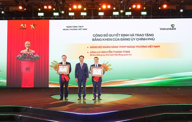 Đại diện Đảng ủy Chính phủ, ông Lại Xuân Lâm - Phó Bí thư Chuyên trách trao bằng khen của Đảng ủy Chính phủ tặng Đảng bộ Vietcombank vì đã có thành tích xuất sắc, tiêu biểu hoàn thành vượt mức các chỉ tiêu Nghị quyết Đại hội nhiệm kỳ 2020-2025 và tặng bằng khen cho cá nhân ông Nguyễn Thanh Tùng - Bí thư Đảng ủy, Chủ tịch HĐQT Vietcombank (ngoài cùng bên phải) vì những thành tích xuất sắc trong thực hiện Nghị quyết Đại hội nhiệm kỳ 2020-2025; ông Lê Quang Vinh - Phó Bí thư Đảng ủy, Thành viên HĐQT, Tổng Giám đốc (ngoài cùng bên trái) đại diện Đảng bộ Vietcombank nhận bằng khen tập thể