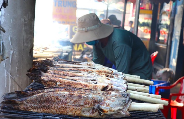 Với cá lóc nướng cúng ngày vía Thần Tài, phải để nguyên con, không cạo vảy, không cắt vi và đuôi. Trong thân mỗi con cá đều được xiên vào một cây mía đã róc sạch vỏ. Cây mía này ngoài công dụng xoay trở cá khi nướng còn tạo ra chất nước ngọt thấm vào thân cá, giúp món cá nướng chín thơm ngon hơn (Ảnh: T. Hồng).