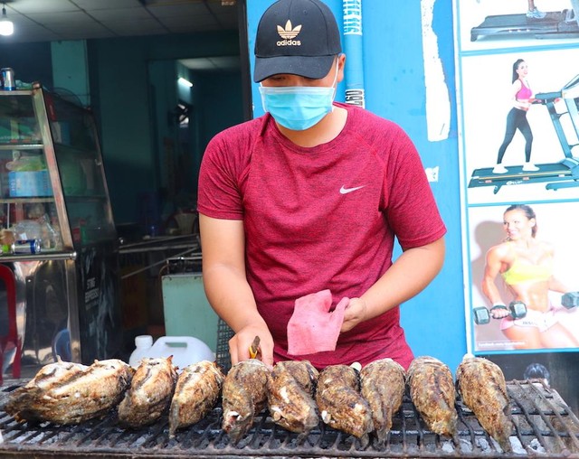 Người nướng cá phải liên tục xoay trở, cạo lớp vảy khét bên ngoài cũng như quét thêm lớp dầu bên ngoài cá (Ảnh: T. Hồng).